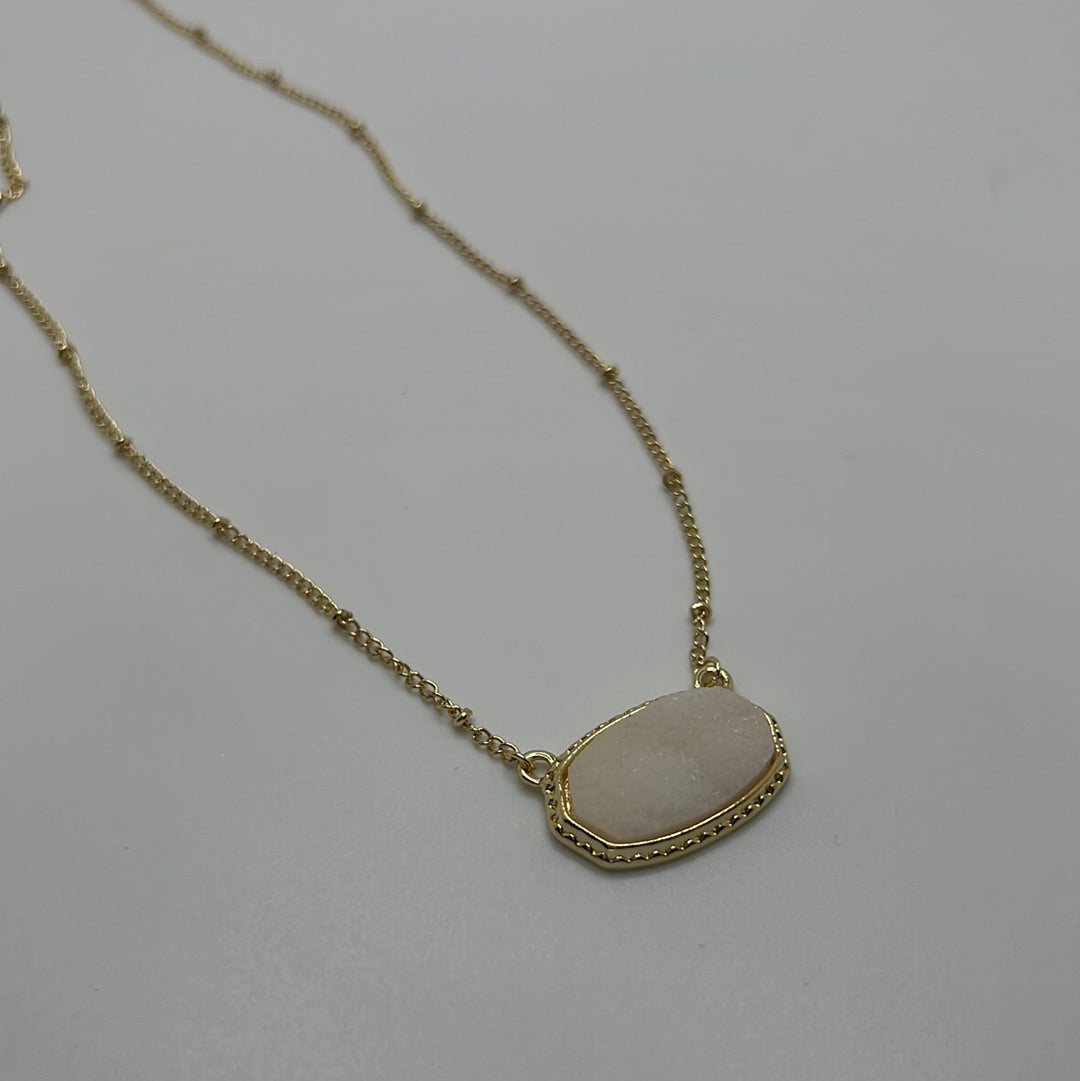 Gold chain necklace with white pendant